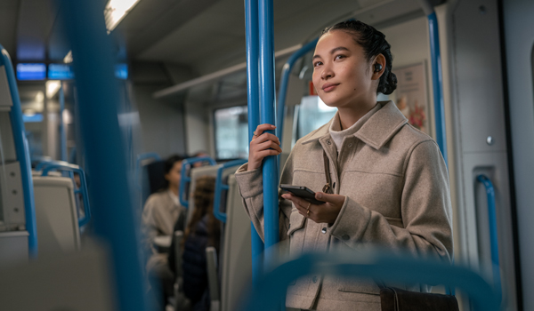 電車の中で音楽を聴く女性